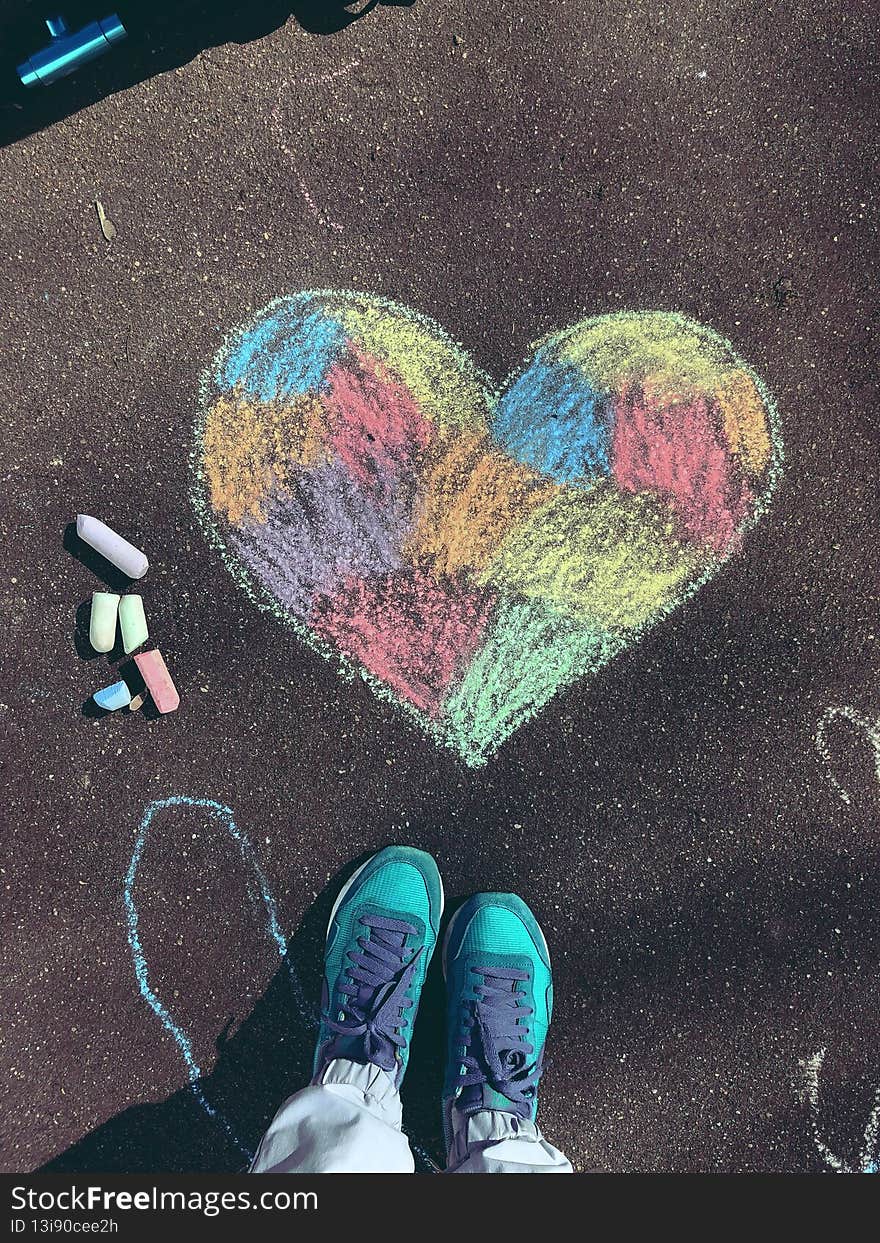 Beautiful colored heart drawn with crayons on the asphalt