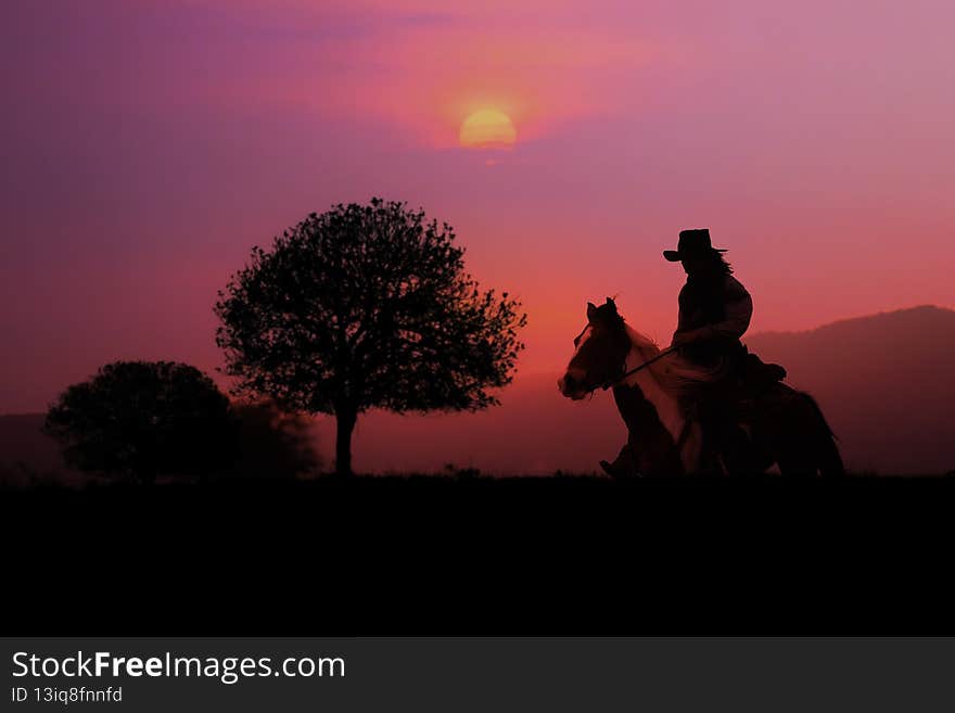 The silhouette of the cowboy and the setting sunset