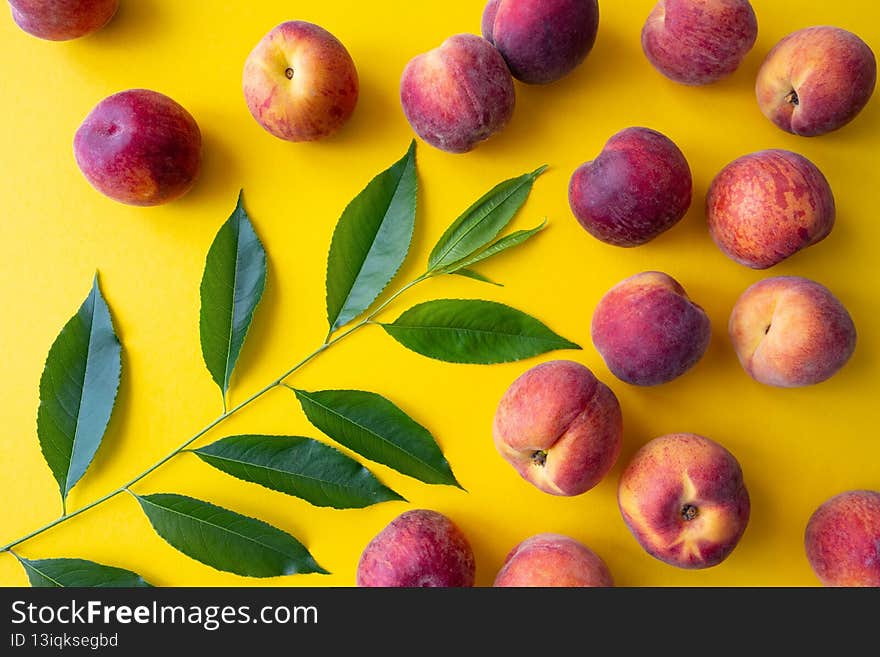 Many ripe peaches on a yellow background, close-up
