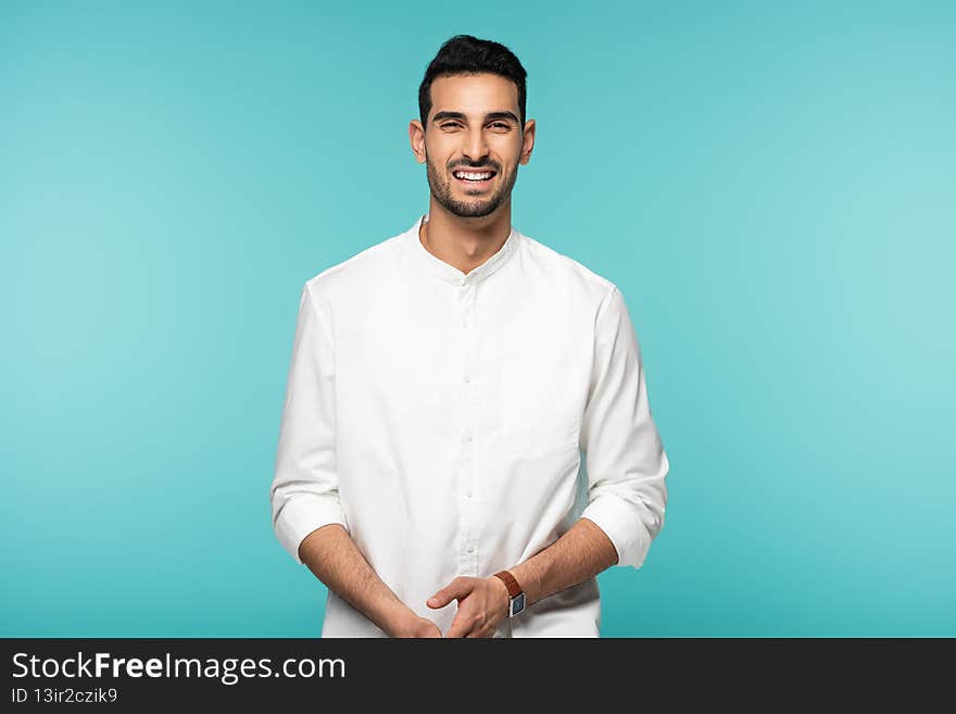 Arabian man in white shirt smiling at camera isolated on blue,stock image