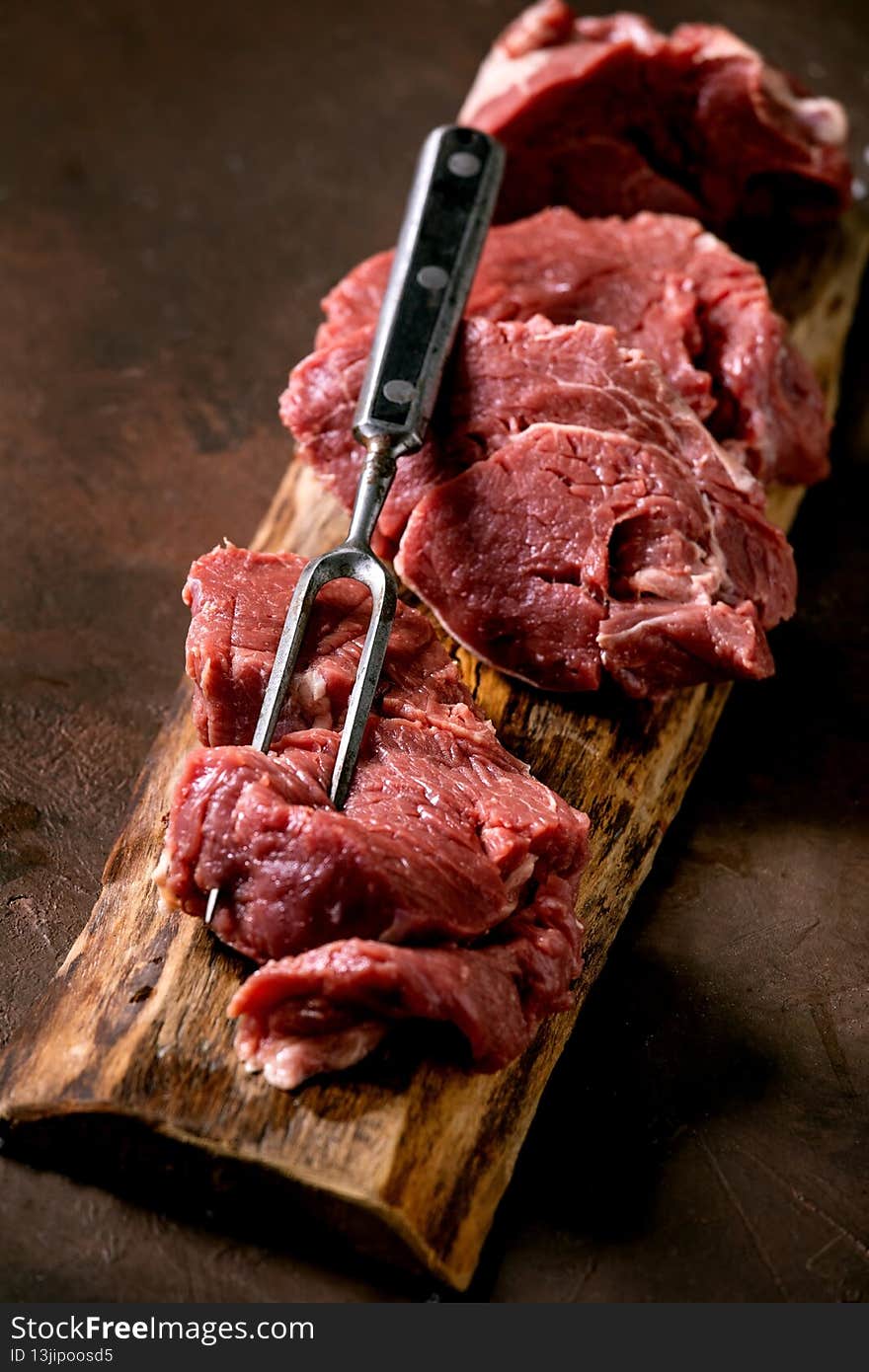 Fresh whole raw beef tenderloin on wooden board
