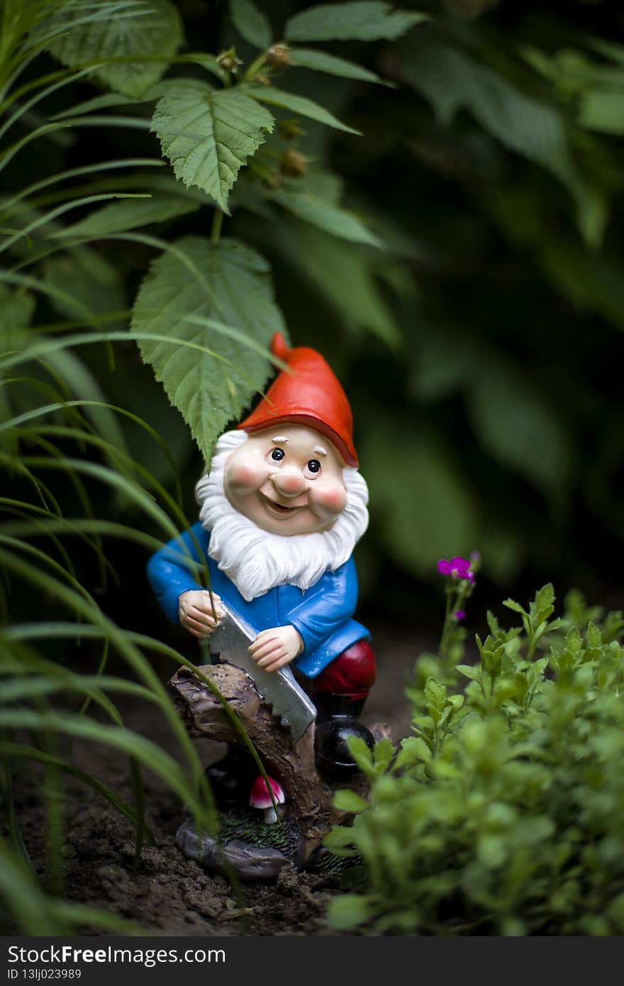 Garden figure gnome with saw