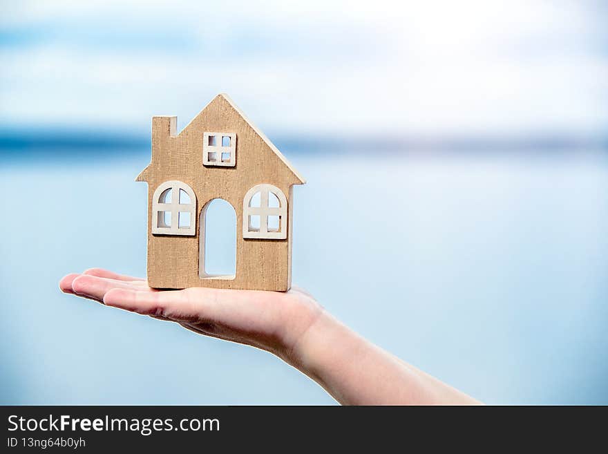 Girl holding the symbol of the house over the sea