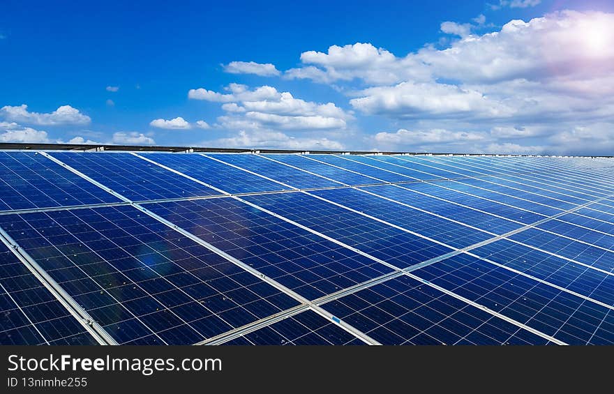 Solar cell panels installed on the roof top of a house with white clouds ,blue sky and the sunlight, to provide power to the house, to go green energy concept. Solar cell panels installed on the roof top of a house with white clouds ,blue sky and the sunlight, to provide power to the house, to go green energy concept