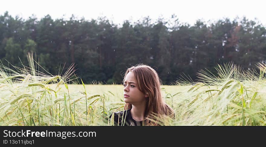 Portrait image of a young girl walking in a field sown with wheat. Portrait image of a young girl walking in a field sown with wheat