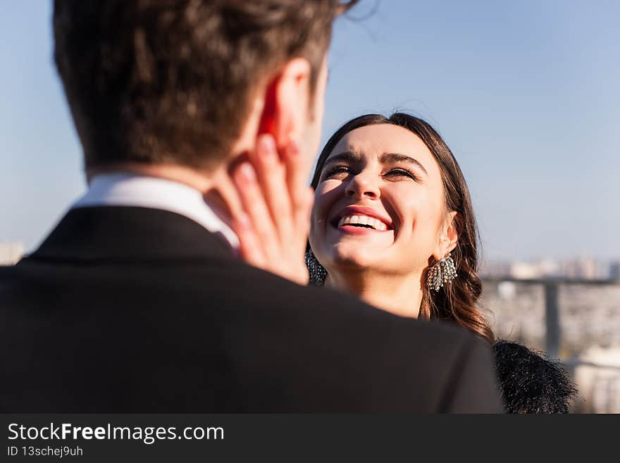 joyful woman touching face of blurred boyfriend,stock image