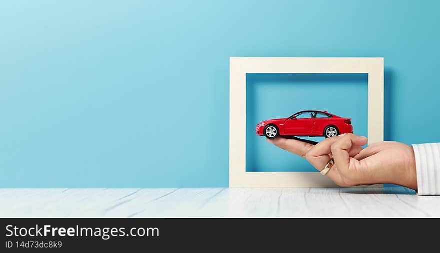 Businessman hand holding a car model, insurance