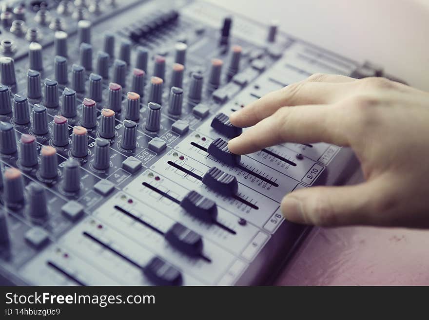 Expert adjusting audio mixing console
