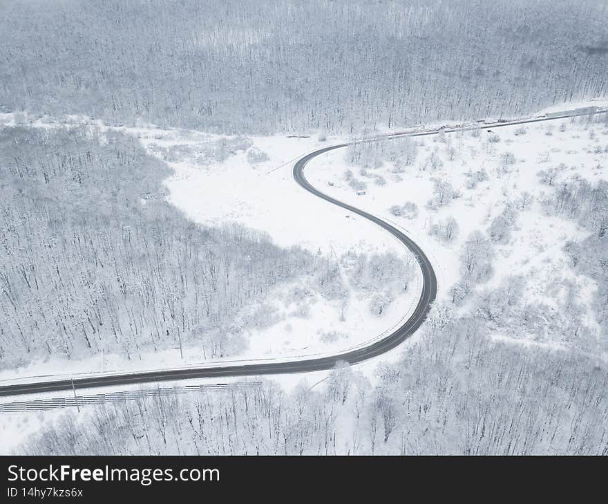Drones Eye View - winter winding road from the high mountain pass in South Russia. Great road trip trough the dense