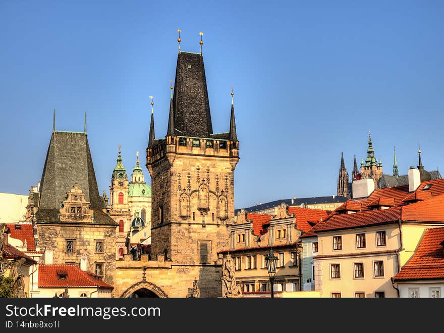 Malostranska district of Prague and the St Nicholas church, Prague towers lit by morning yellow sun. Malostranska district of Prague and the St Nicholas church, Prague towers lit by morning yellow sun