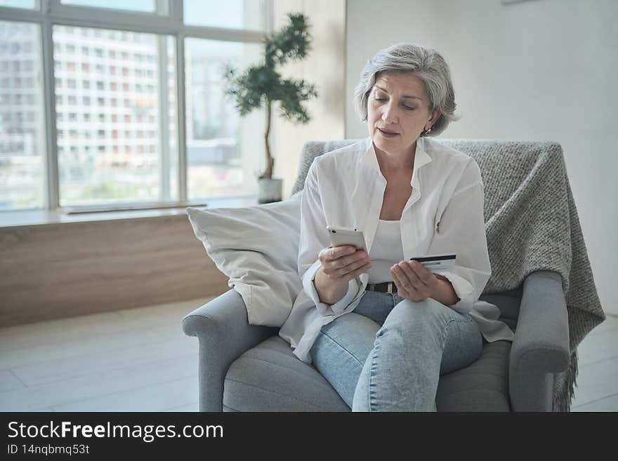 Senior woman spending money in internet websites and stores and making online payments. Retired pensioner buying clothes, food and pharmaceuticals. Purchasing concept in electronic pharmacy.