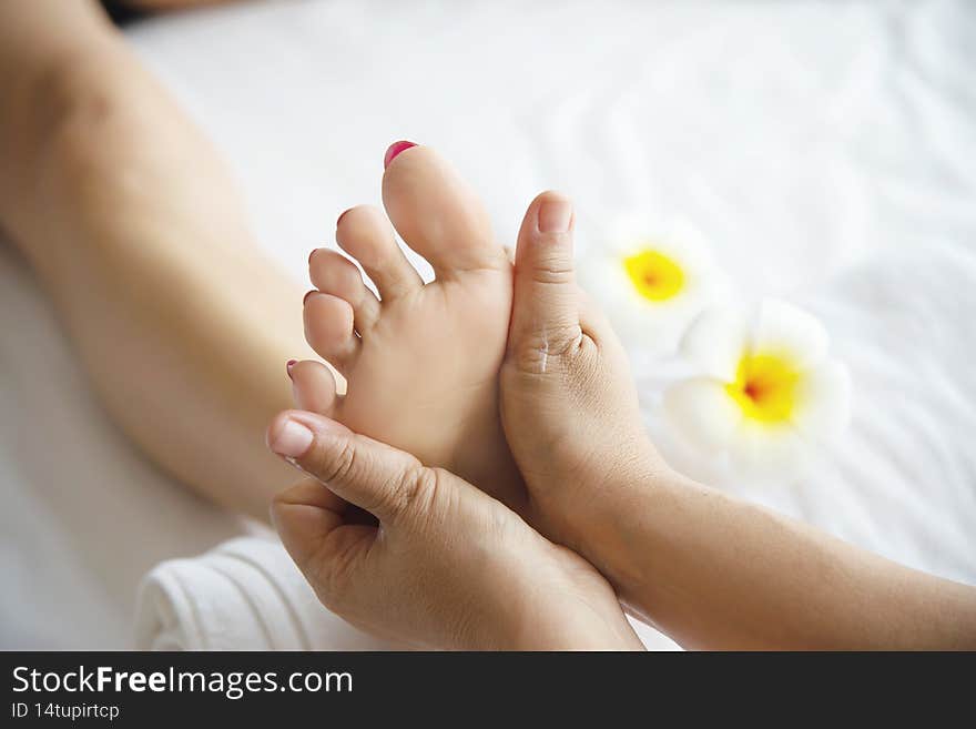 Woman receiving foot massage service from masseuse close up at hand and foot - relax in foot massage therapy service concept
