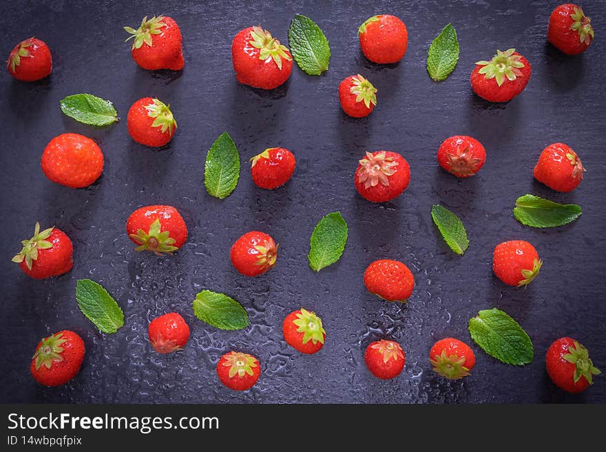 Sprinkled ripe berry - strawberry and mint leaves and an inscription on