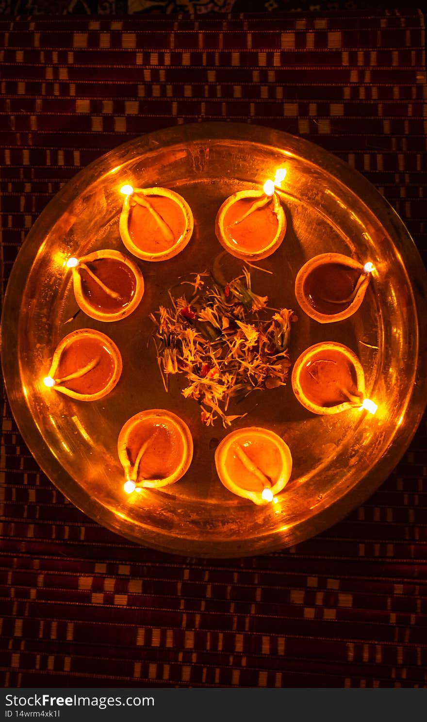 Lighted clay oil lamps with flower petals kept in plat for diwali cultural celebration lightnings in details