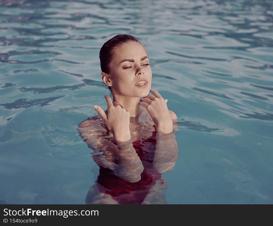 beautiful woman in red swimsuit in the pool luxury cosmetics vacation