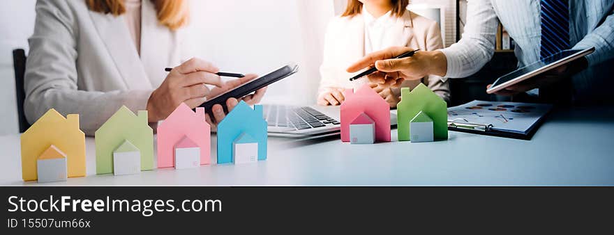 Interracial couple having consultation with a real estate agent inside a new home. Mature male realtor discussing the contract with customer