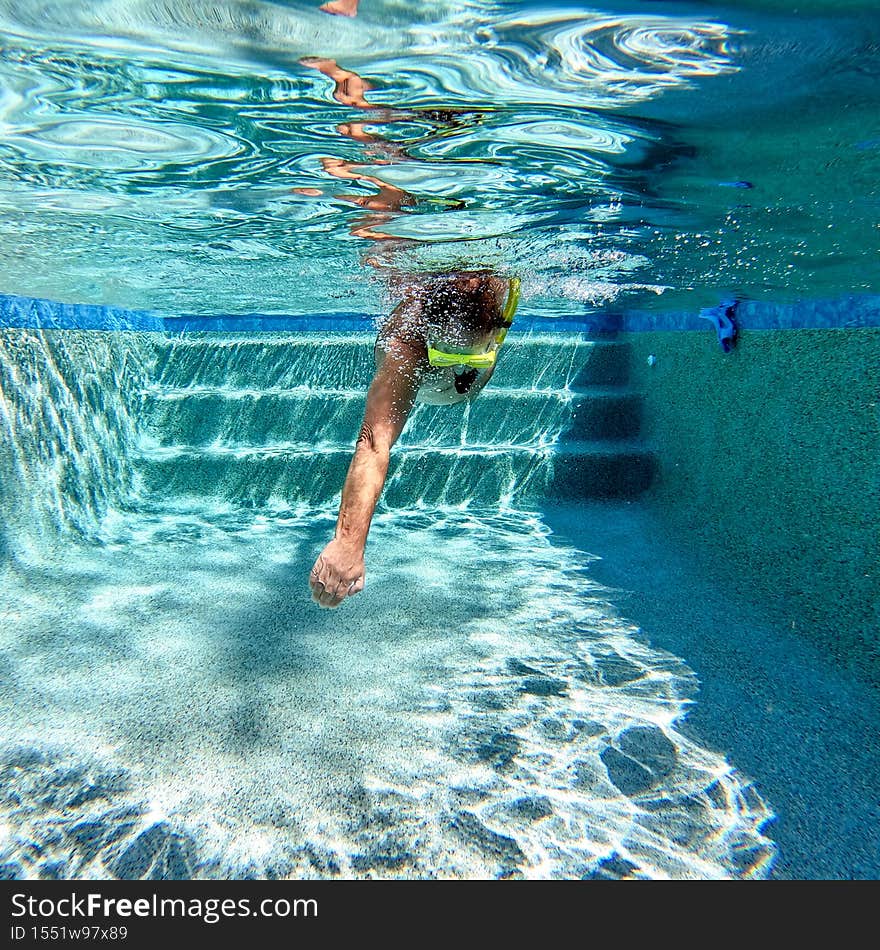 A man swimming freestyle in a swimming clear pool water in on a sunny day in Florida