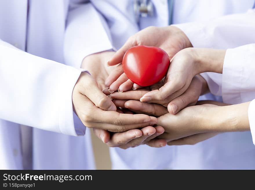 Group of hands holding a red heart. Hand of doctors. donate and insurance, insurance health care, love, family insurance, and CSR concept