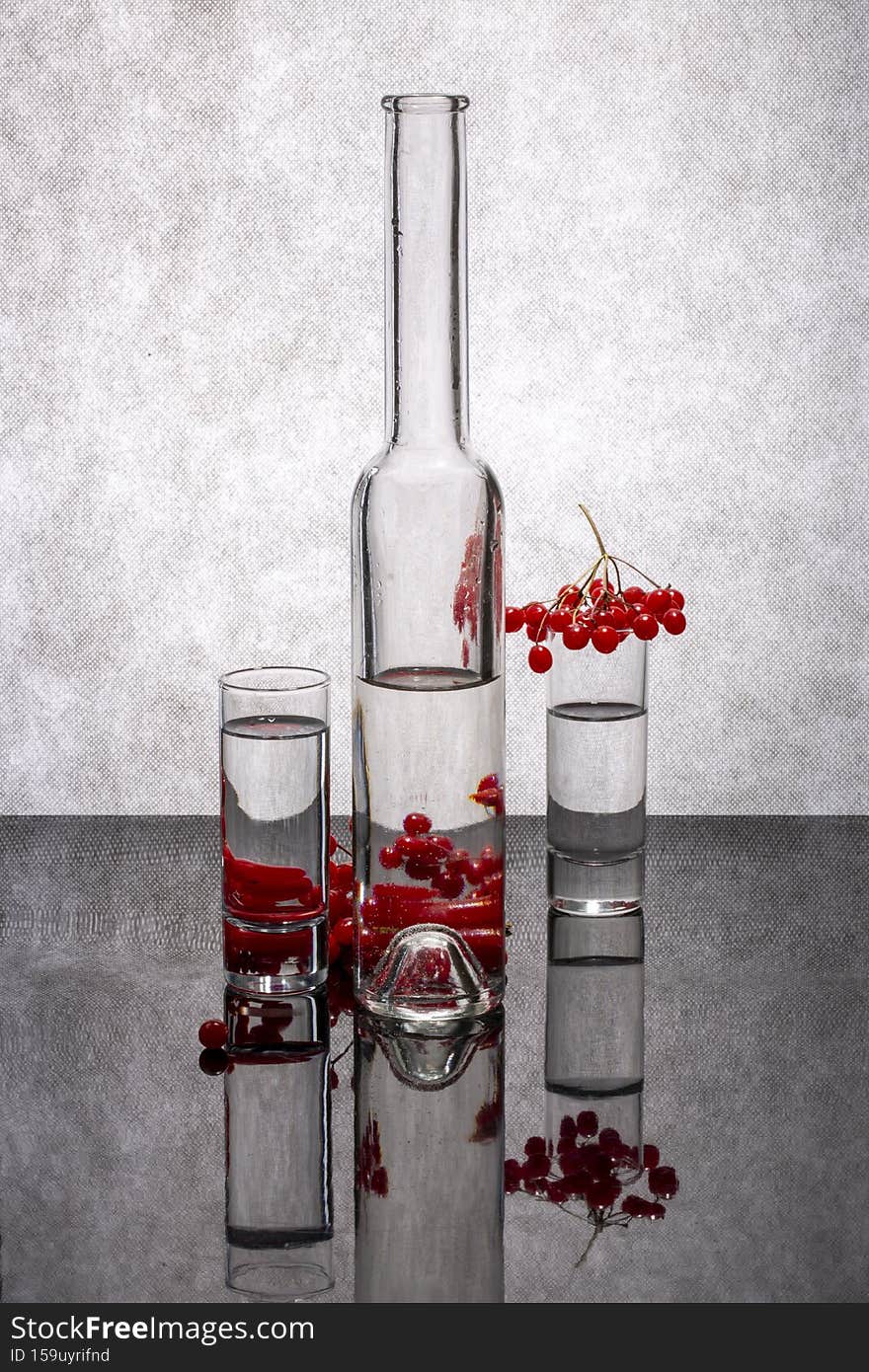 Still life with three glass glasses and red viburnum berries.