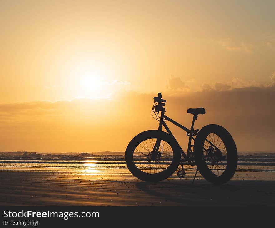 Bicycle on an airfield during a beautiful sunset showing the flare and bright blue bike.silhouette of a bicycle at sunset.