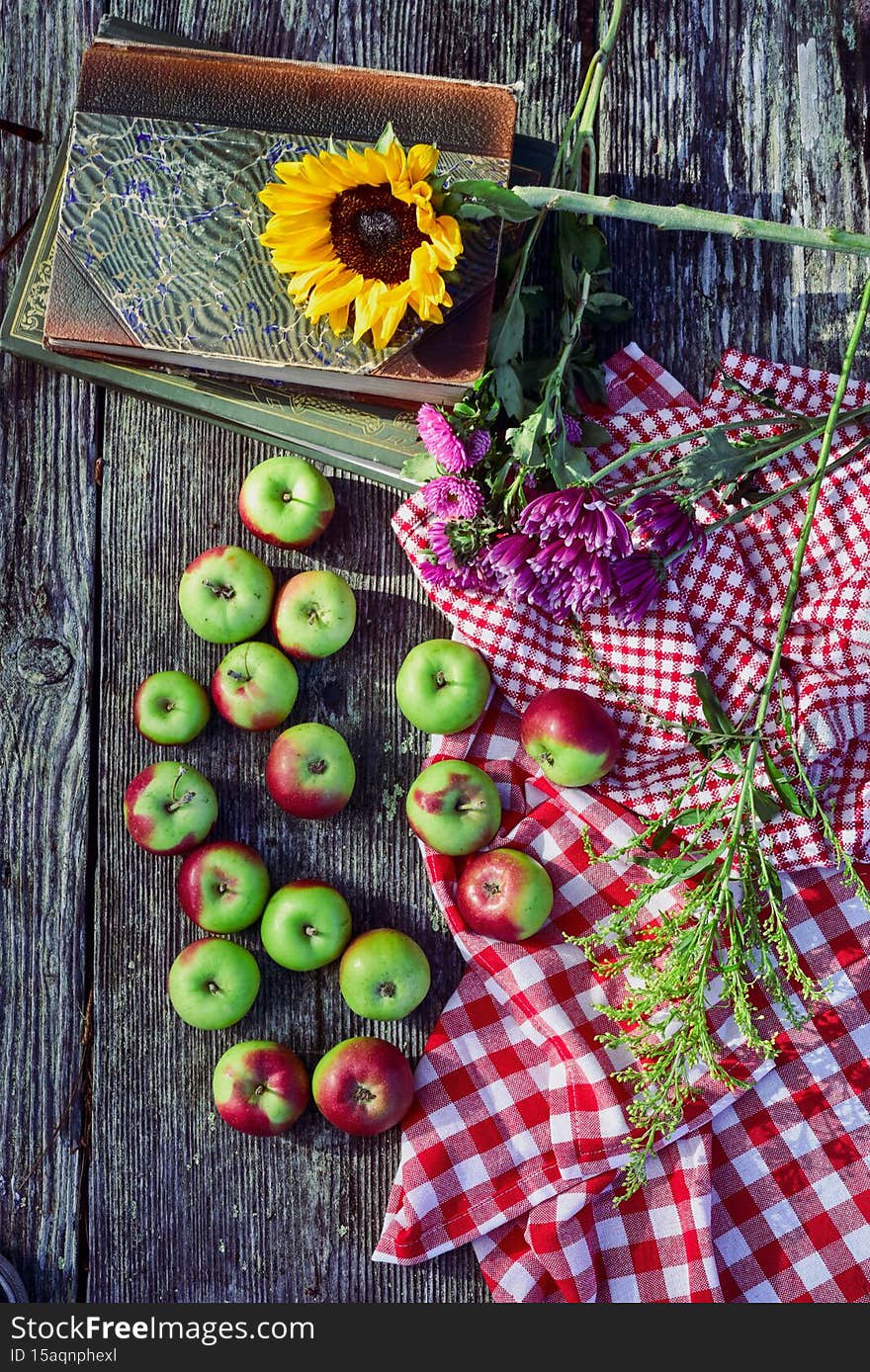 Above view of tabletop still life with autumn apples and cut flowers