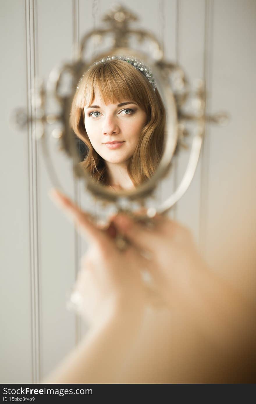 Luxury bride in white dress posing while preparing for the wedding ceremony.