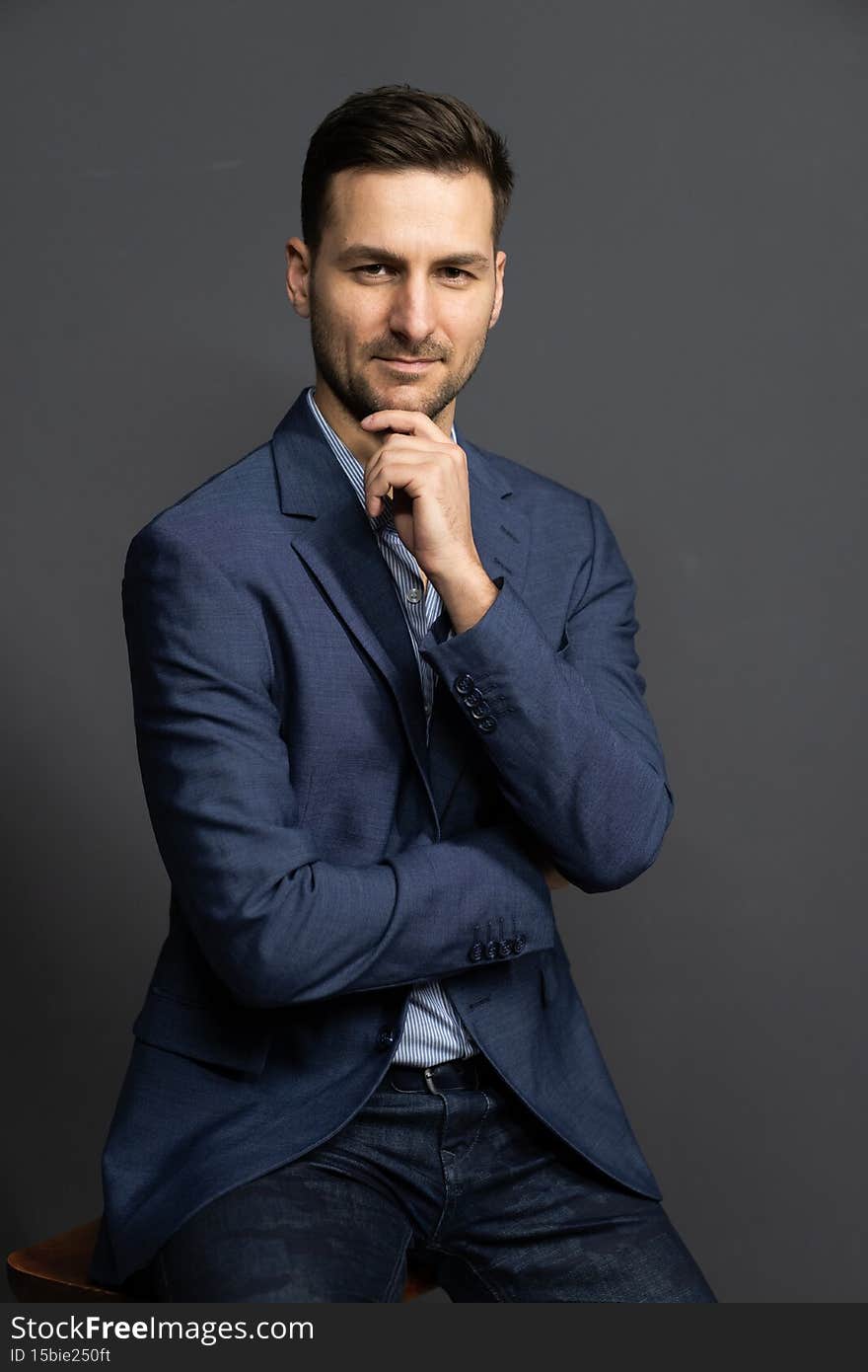 Elegance Businessman in a Blue Formal Waist Up Suit Jacket Gazes Straight to the Camera. Elegant Brown Haired Man Posing