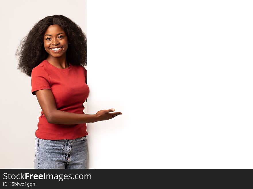 Place For Ad. Black Female Pointing At White Advertisement Board With Palm