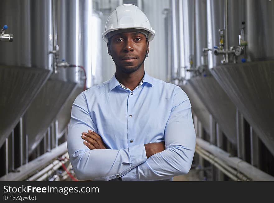 Portrait of professional industry engineer. Technician engineer wearing safety helmet and smile. Large industrial factory background.