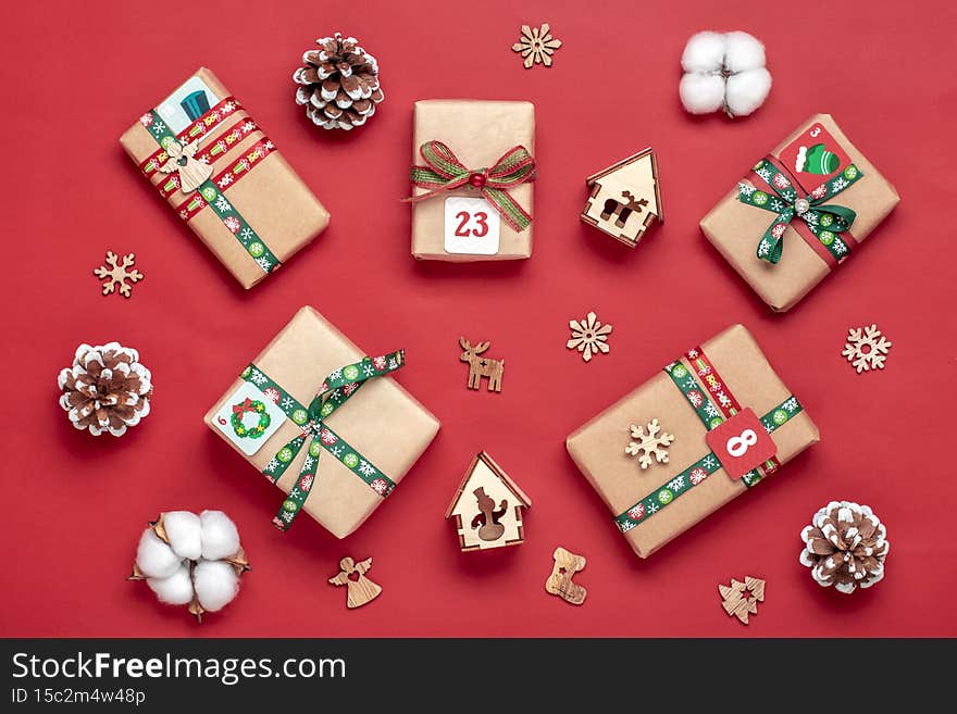 Handmade wrapped red, green gift boxes decorated with ribbons, snowflakes and numbers, Christmas decorations and decor on table