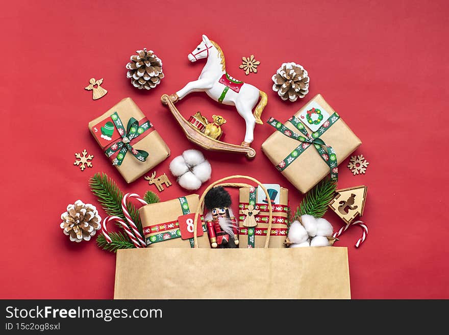 Handmade wrapped red, green gift boxes decorated with ribbons, snowflakes and numbers, Christmas decorations and decor in bag on