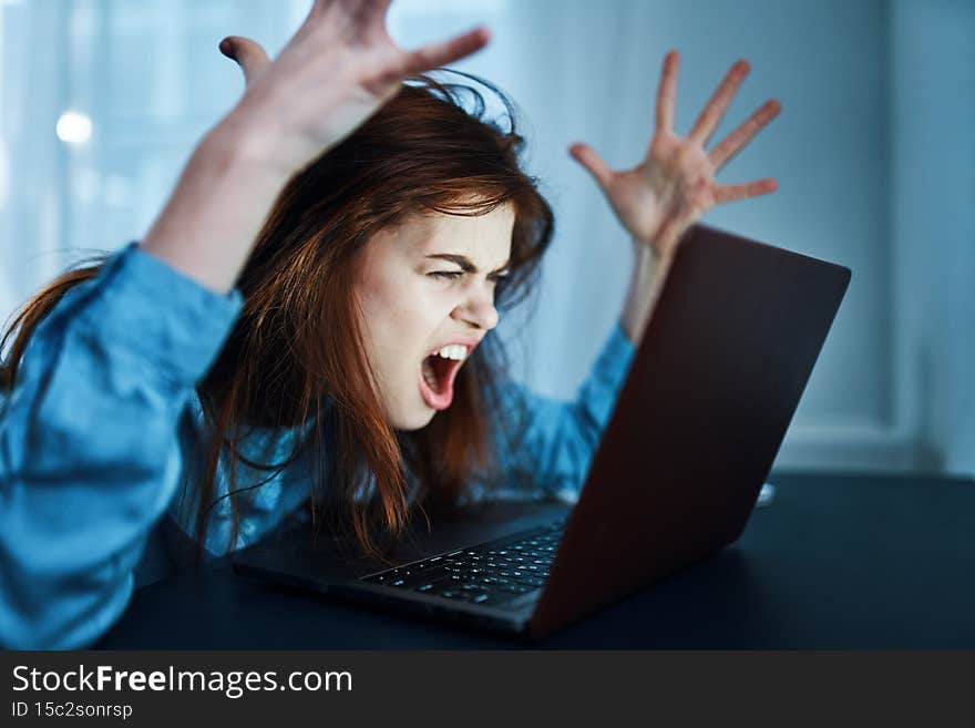 emotional woman in front of laptop at night work disorder
