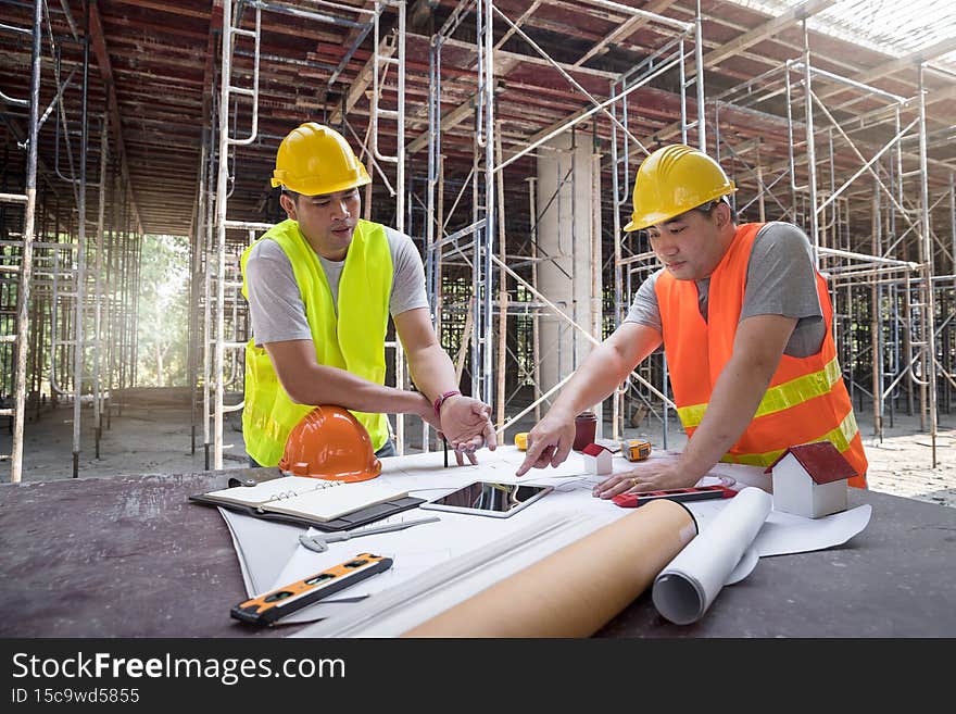 Confident team of architect working together in building construction site. They discussing about new startup project. Architect discuss with engineer about project . Architectural concept.