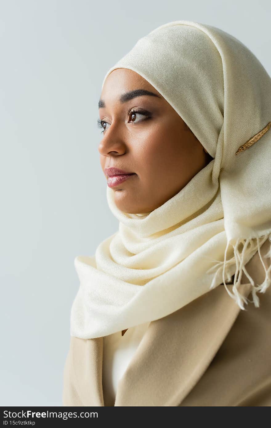 pretty muslim woman in white hijab looking away isolated on grey,stock image