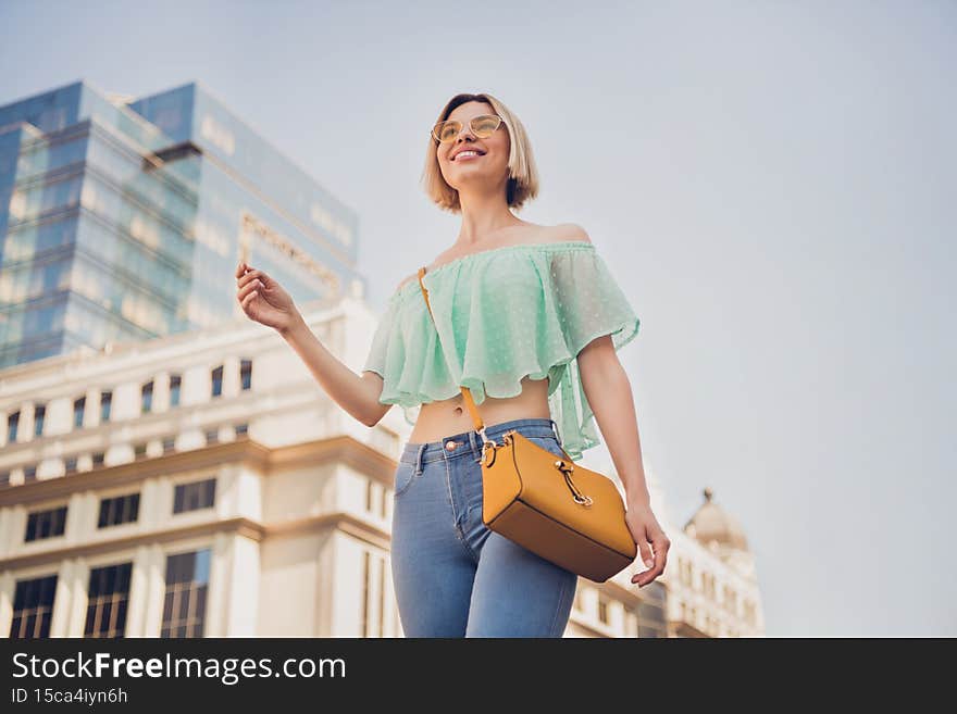 Low angle view photo of young attractive girl happy positive smile walk city trip handbag summer outdoors
