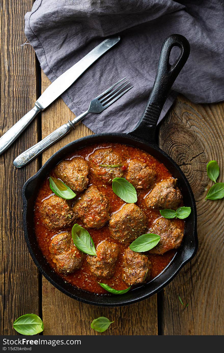 Homemade meatballs in tomato sauce with fresh basil on the table
