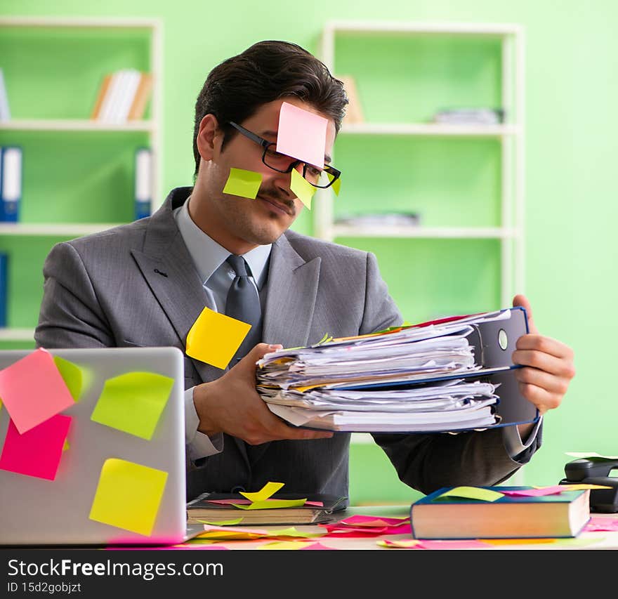 Businessman unhappy with many conflicting priorities sitting in the office