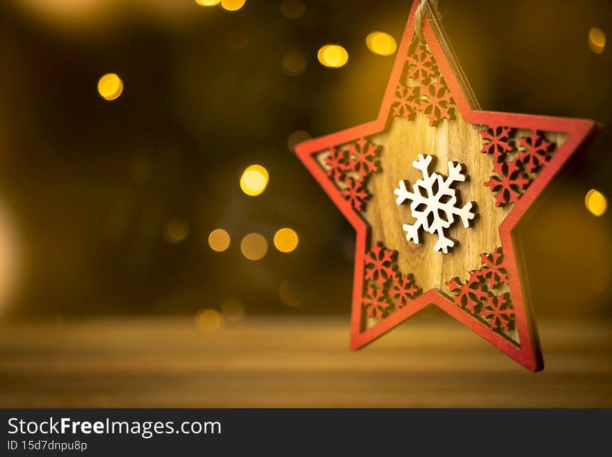 Christmas decoration background. Wooden star close-up, blurred christmas lights and bokeh