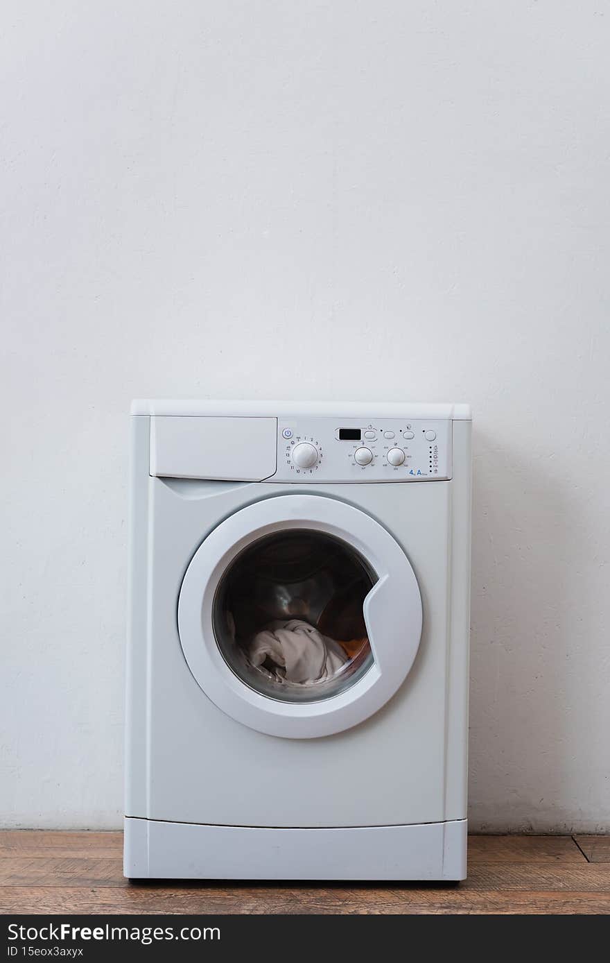 modern washing machine with laundry near