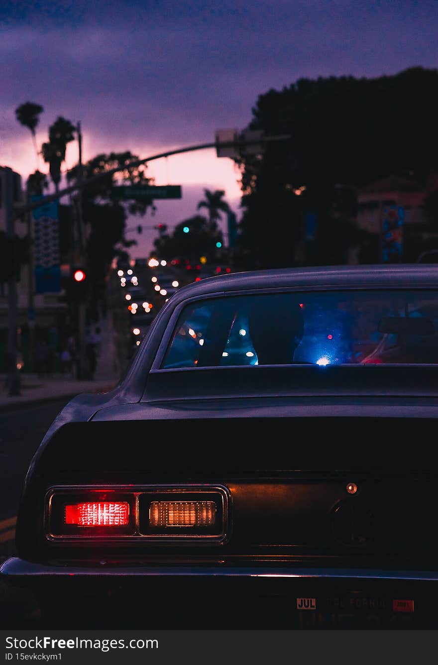 A selective of a classical car on the road in the twilight
