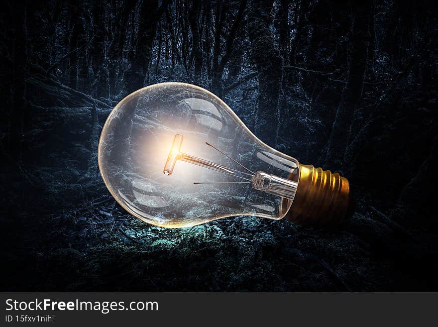 Huge light bulb glowing in the darkness