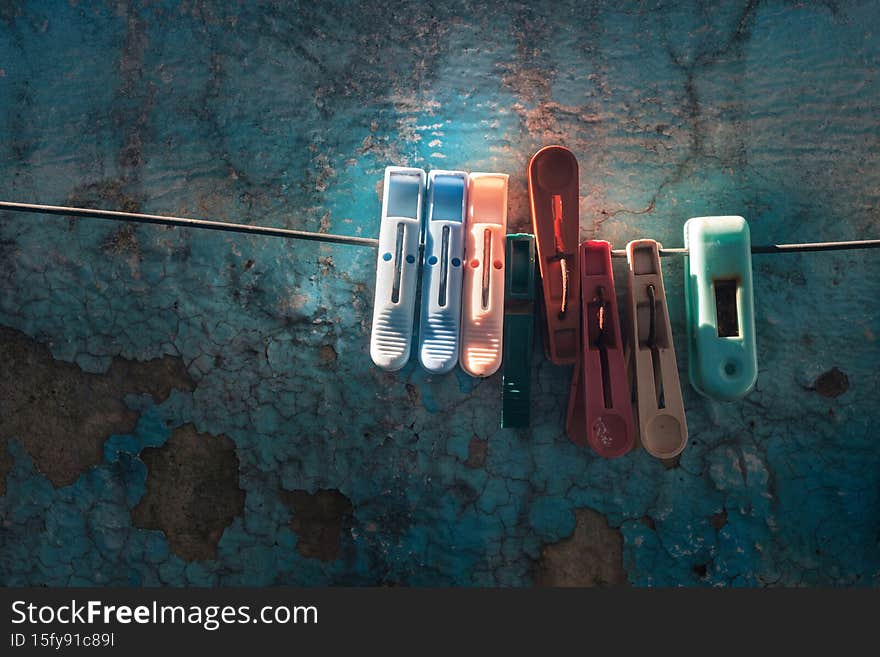 Plastic clothespins hang in a row