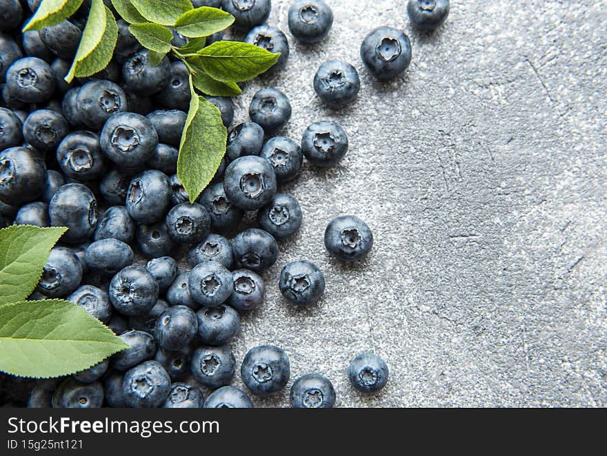 Freshly picked blueberries on a concrete background. Concept for healthy eating. Freshly picked blueberries on a concrete background. Concept for healthy eating