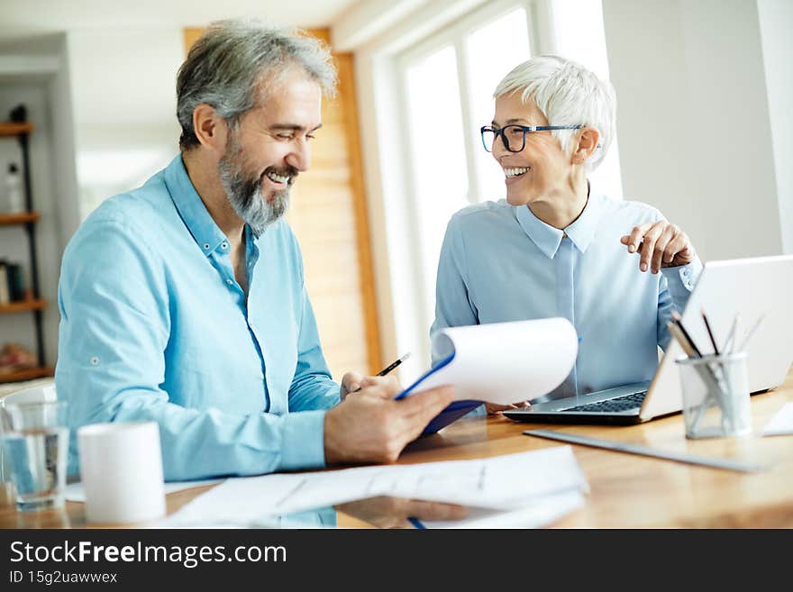 two senior businesspeople signing a contract in the office. two senior businesspeople signing a contract in the office
