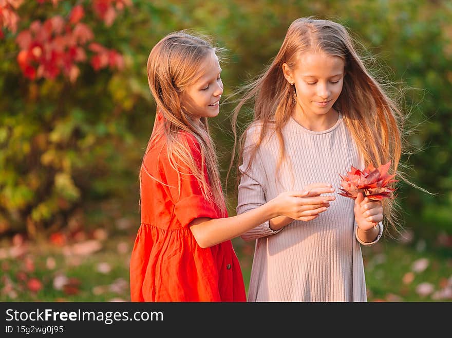Little adorable girls outdoors at warm sunny autumn day