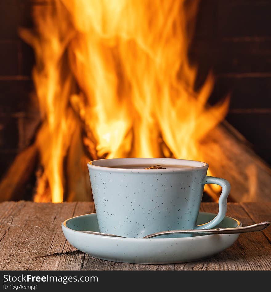 Cup of tea or coffee near a cozy fireplace, in a country house, autumn or winter holidays,horizontal. Cup of tea or coffee near a cozy fireplace, in a country house, autumn or winter holidays,horizontal