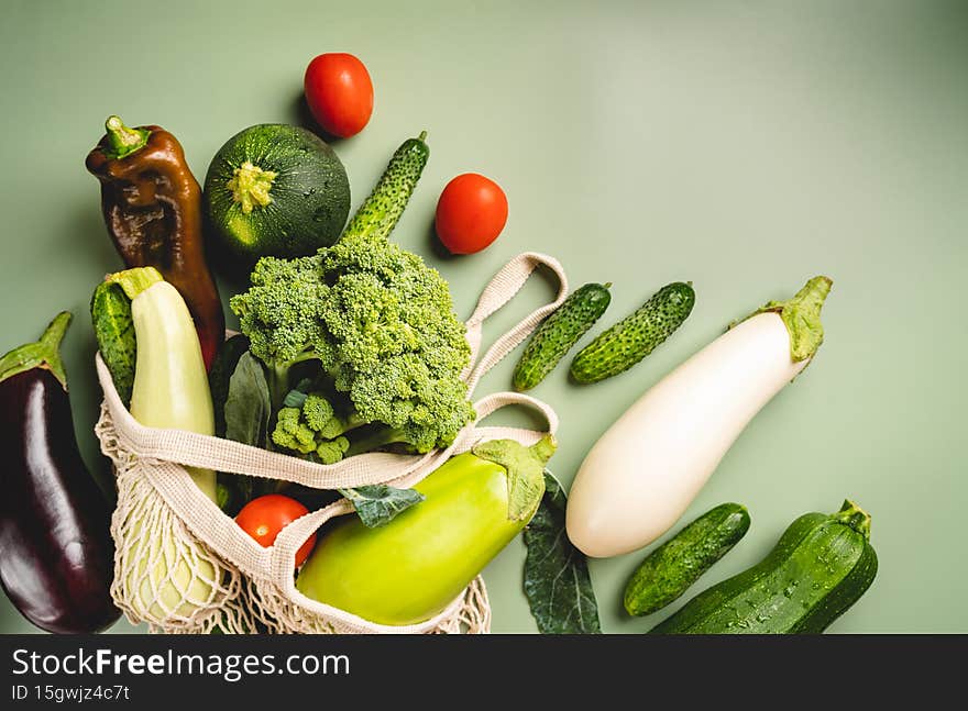 Eco friendly mesh bag with organic green vegetables on green background. Flat lay, top view. Zero waste, plastic free concept. Healthy clean eating diet and detox. Eco friendly mesh bag with organic green vegetables on green background. Flat lay, top view. Zero waste, plastic free concept. Healthy clean eating diet and detox