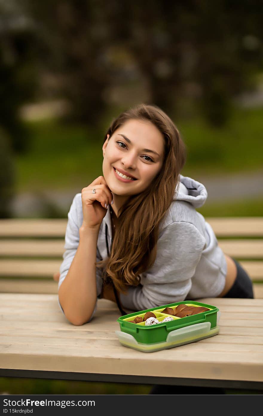 beautiful caucasian woman with long hair in a tracksuit in the courtyard near the house , lady in grey sportswear with a