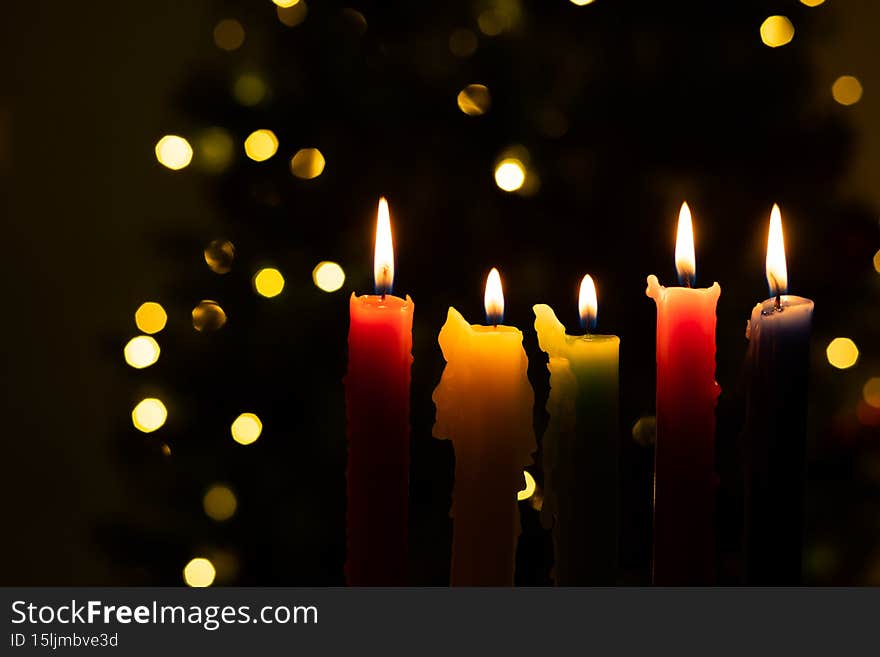 Candlelight Day. Traditional Colombian holiday. Group of colored candles lit at night with unfocused lights in the background. Copy space
