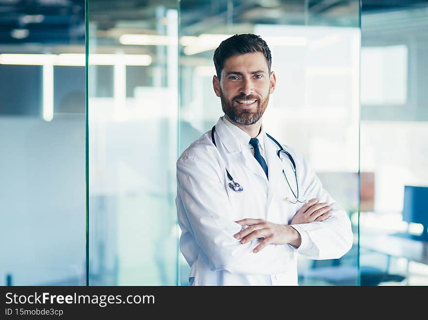 Successful male doctor smiles and looks at the camera in the clinic.